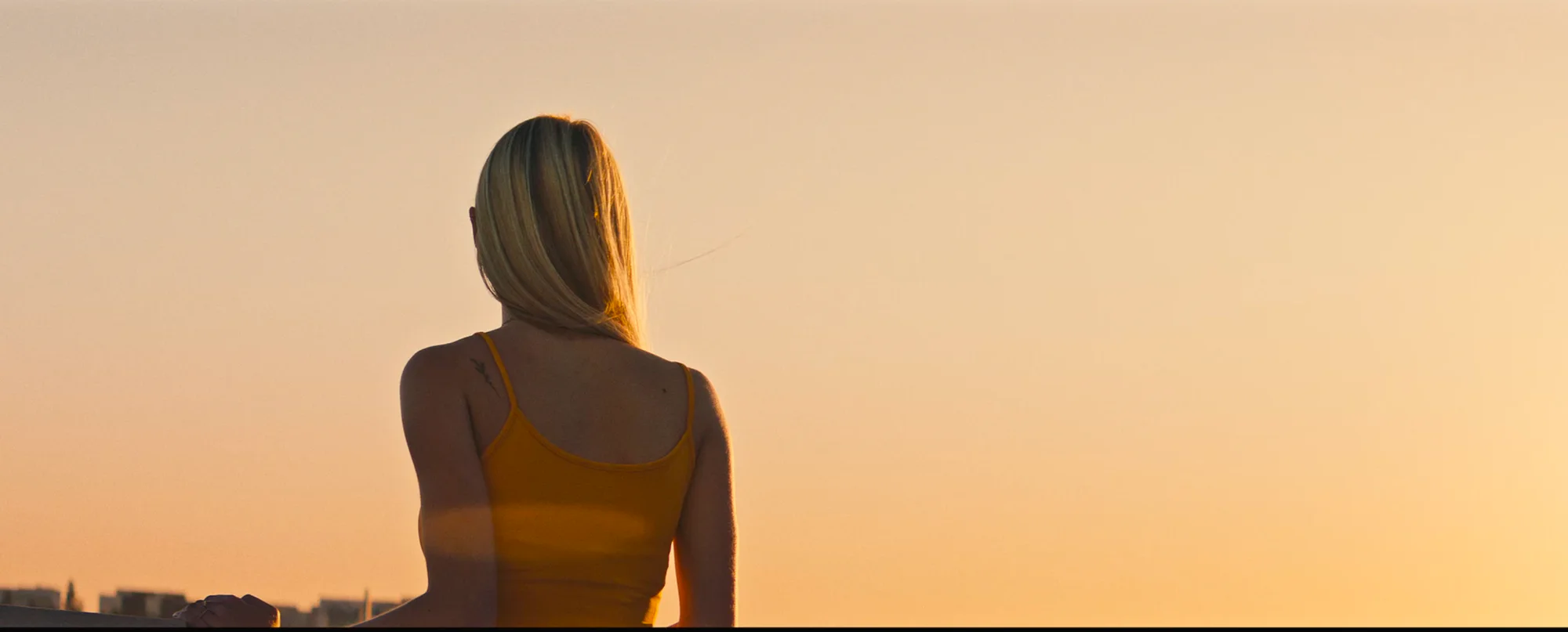 A woman silhouetted by the last warm light